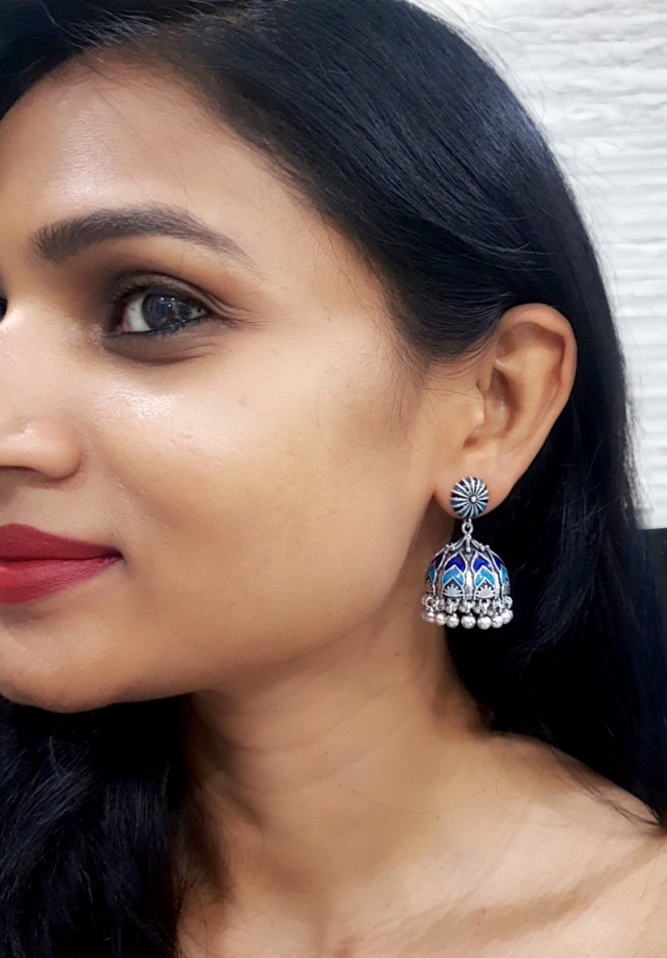 Beautiful Ela enamel jhumka earrings in antique silver, crafted from brass and enamel, designed to elevate your ethnic and festive look. Measuring 4 cm x 2 cm x 1 cm and weighing 28g, these skin-friendly earrings come in Sutra Designs’ custom jewelry packaging, perfect for traditional celebrations