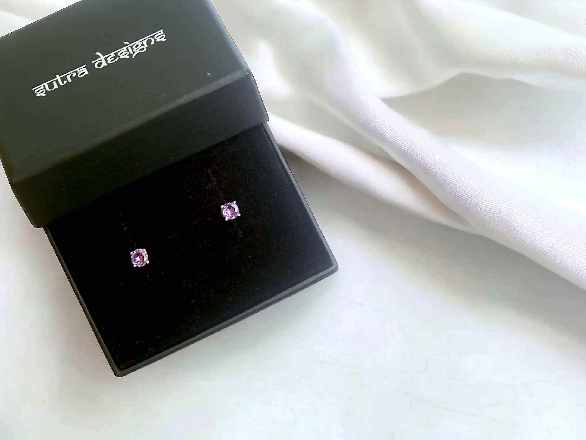 Purple Zircon Stud Earrings in silver, crafted from brass and featuring a 6mm purple zircon stone. Lightweight at 1.5g with skin-friendly material for comfort. Delivered in Sutra Designs' custom jewelry packaging, ensuring a luxurious finish