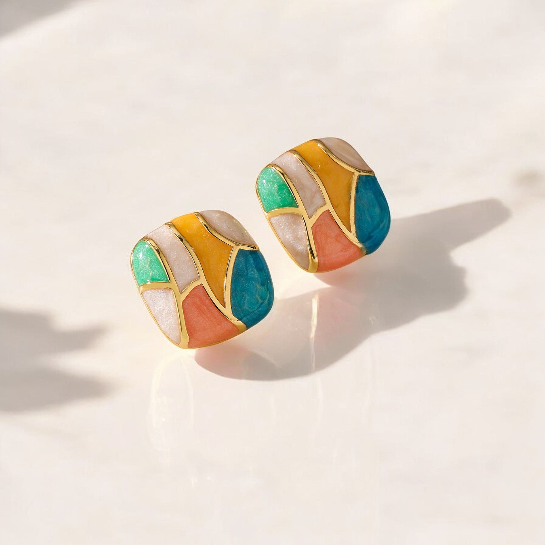 Chic color block enamel 18K gold-plated ear studs, crafted in durable stainless steel, measuring 2 cm x 2 cm and weighing 8g. Hypoallergenic, tarnish-free, water-resistant, and designed for exceptional durability, these studs come in Sutra Designs’ custom jewelry packaging