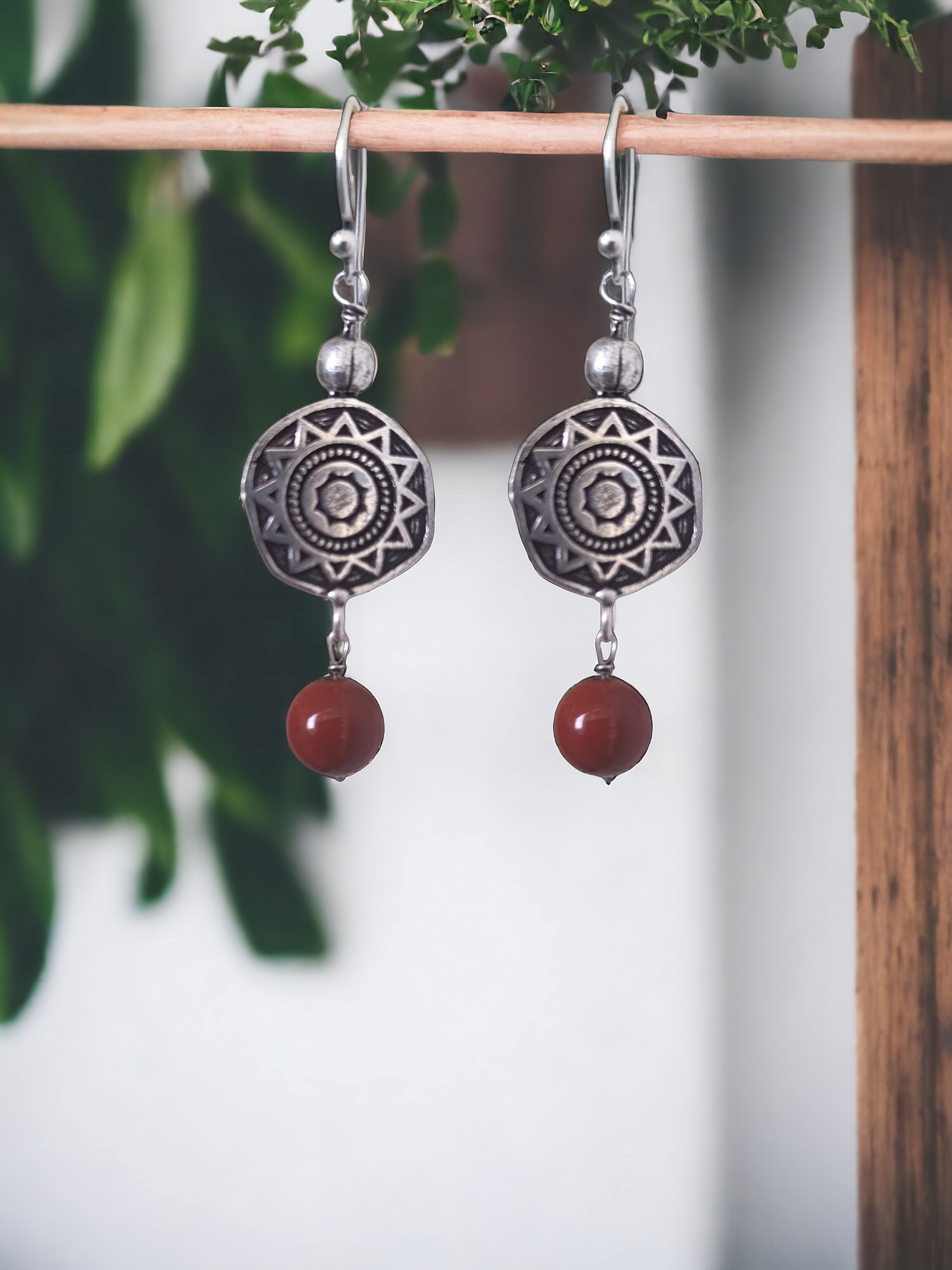 Rubina Red Jasper Charm Hoop Earrings in antique silver, crafted from brass and red jasper. Featuring a 1.5cm x 6mm design, these lightweight 5.6g earrings add a pop of color to any ensemble. Skin-friendly material ensures comfort, while their timeless charm makes them versatile for casual or elegant looks. Delivered in Sutra Designs' custom jewelry packaging for an added touch of luxury