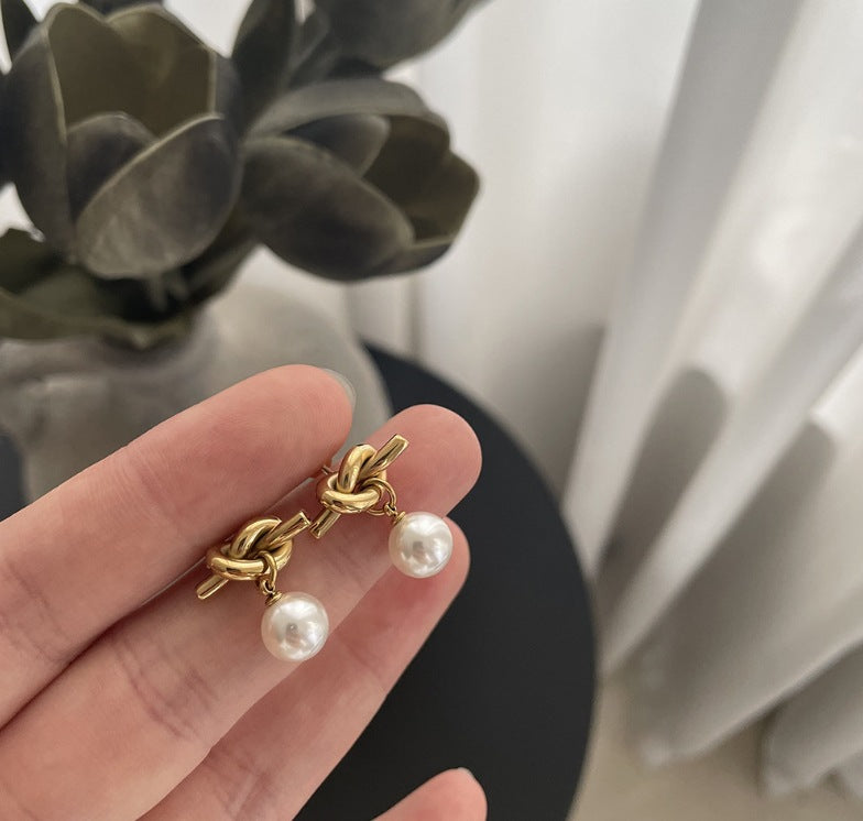 Pearl Drop 18K Gold-Plated Earrings, crafted from stainless steel with a sophisticated design. Features hypoallergenic material, tarnish-free finish, and water-resistance for durability. Measures 18.3mm x 16cm x 8mm and weighs 2.6g. Delivered in Sutra Designs' custom jewelry packaging for an elegant presentation