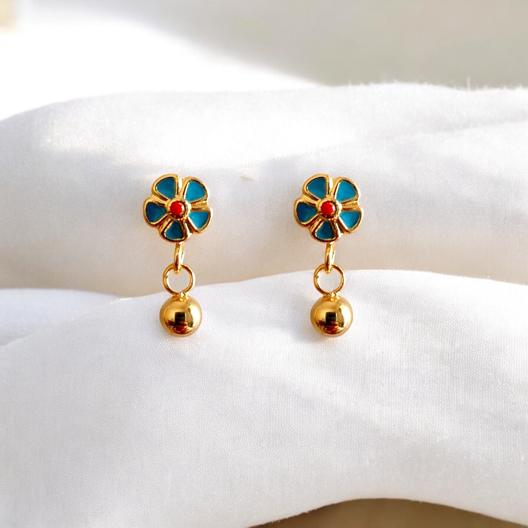 Delicate Sweet Flower Enamel Drop Earrings, available in 18K Gold Plated. Crafted from stainless steel, these earrings feature a charming floral design with a total size of 14.4mm x 6.2mm x 3mm and a total weight of 2g. Hypoallergenic, tarnish-free, water-resistant, and built for durability, these earrings offer effortless elegance. Delivered in a Sutra Designs custom jewelry packet for a premium experience